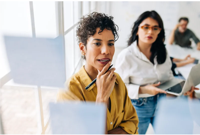 Woman reviewing strategy notes during collaborative planning session.