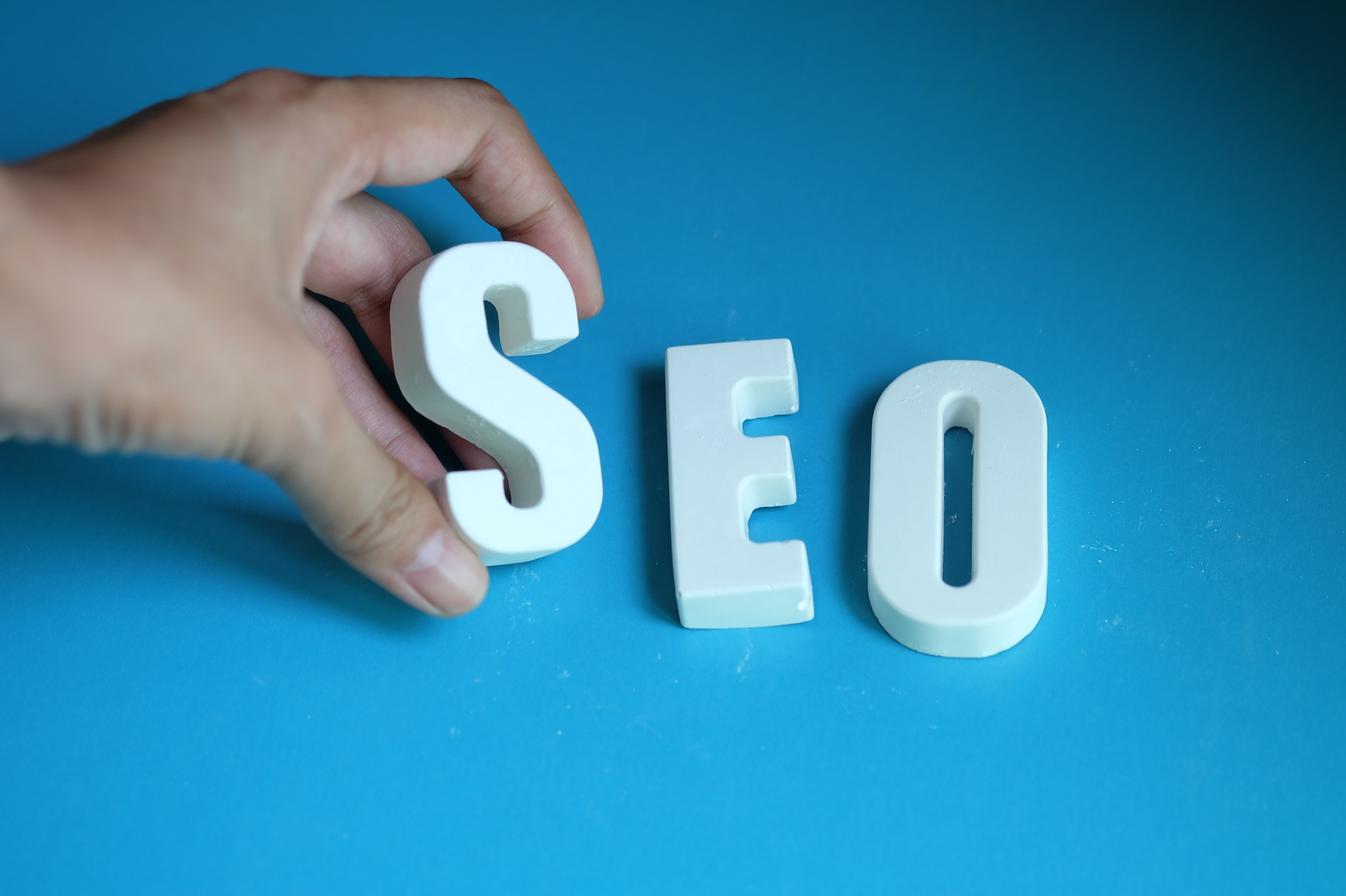 Affordable SEO services for small business shown with a laptop on a desk alongside a notebook, pens, and a mobile phone.
