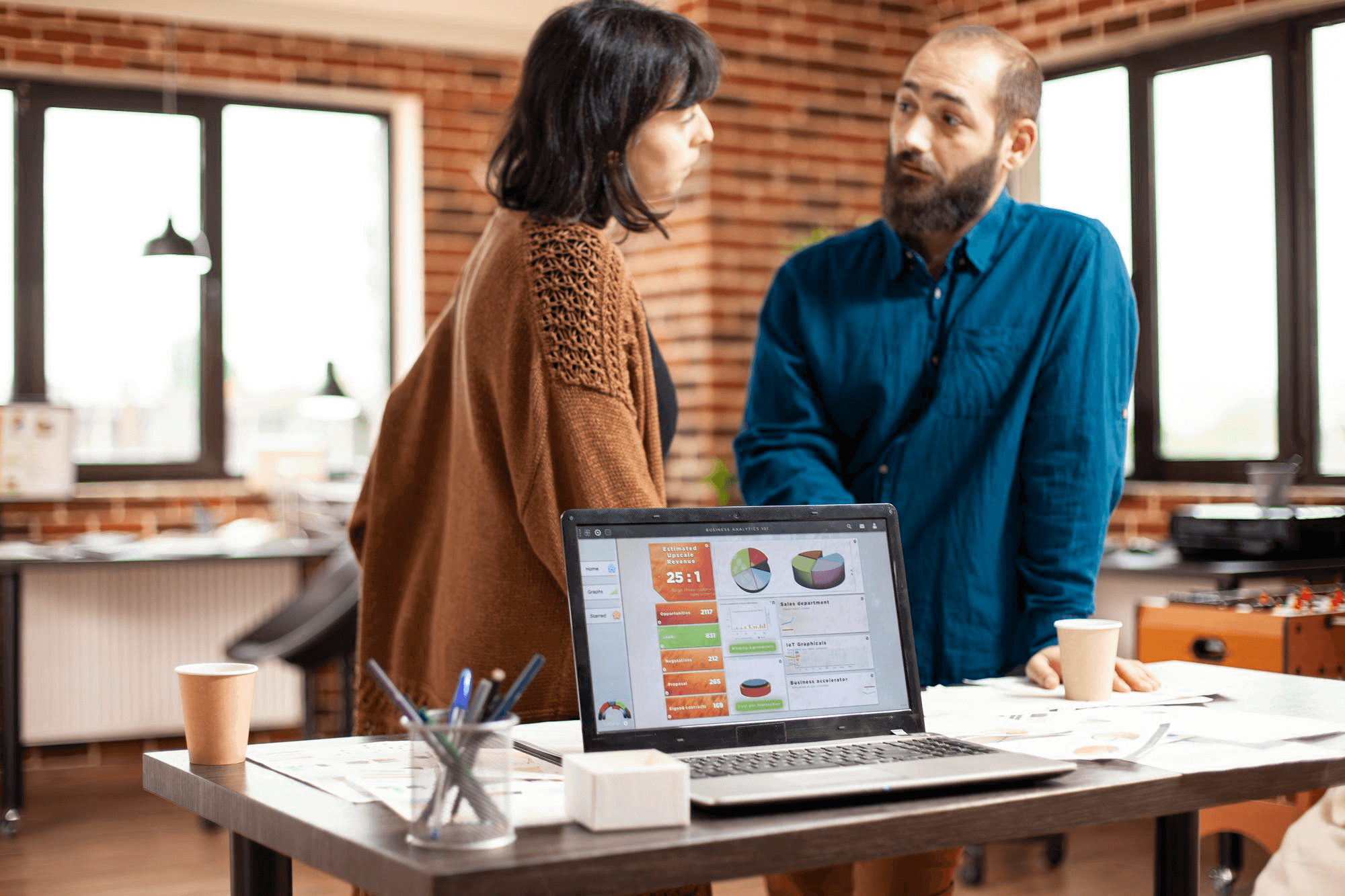 Doctor checking a wheelchair-bound patient, another talking to the receptionist, and one reading a brochure—capturing a busy clinic boosted by urgent care SEO.